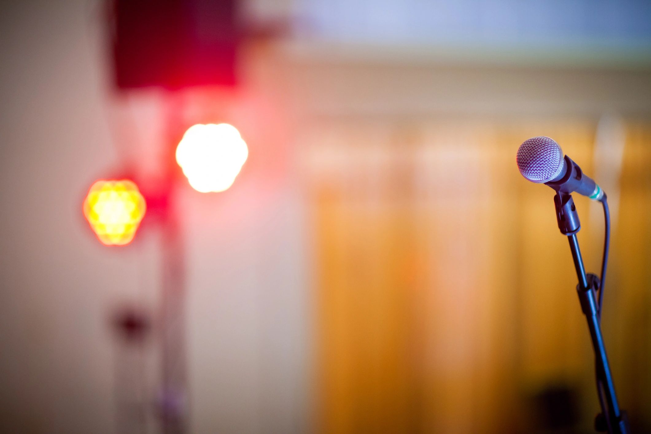 Microphone with warm bokeh lights in a conference setting