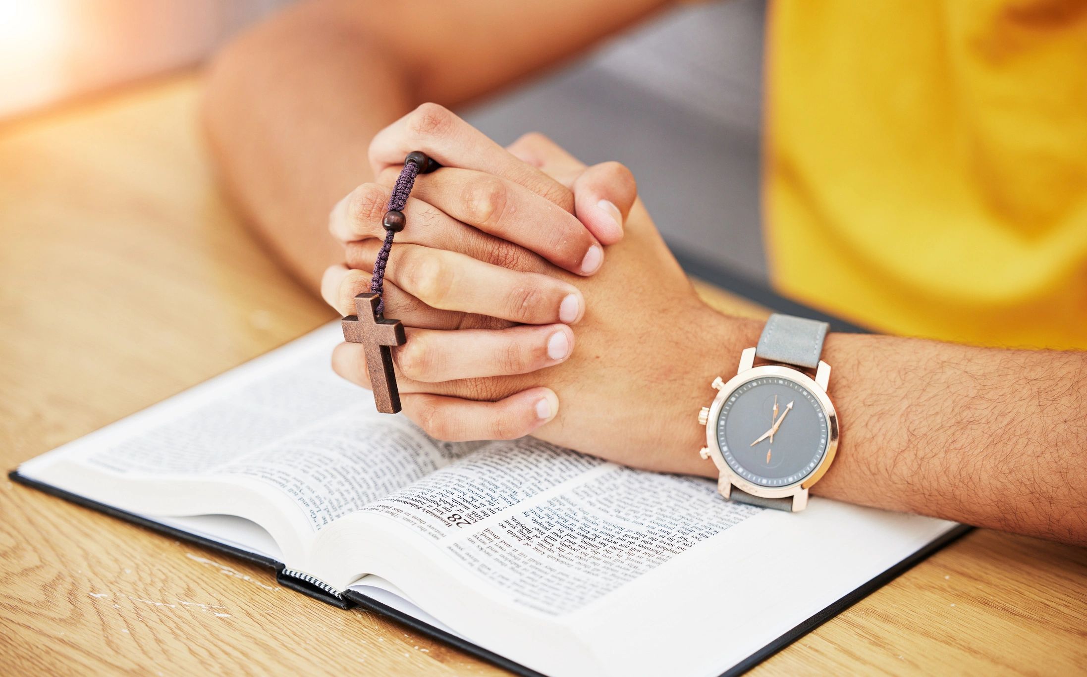 Hands holding a Bible in prayer